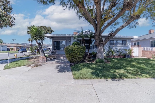 ranch-style home featuring a front yard and fence