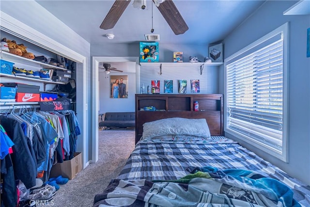 carpeted bedroom featuring visible vents, a closet, and a ceiling fan