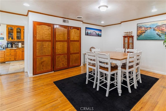 dining area with visible vents, recessed lighting, light wood-style floors, and ornamental molding