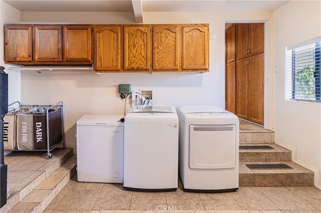 laundry area with separate washer and dryer, light tile patterned floors, and cabinet space