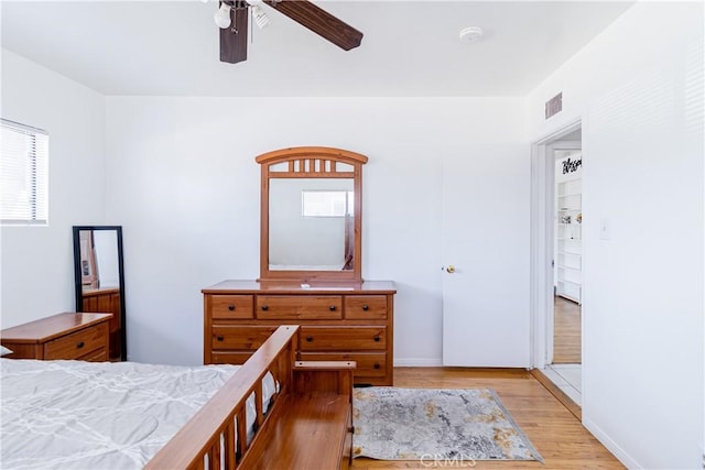 bedroom with light wood-style flooring, a ceiling fan, and visible vents