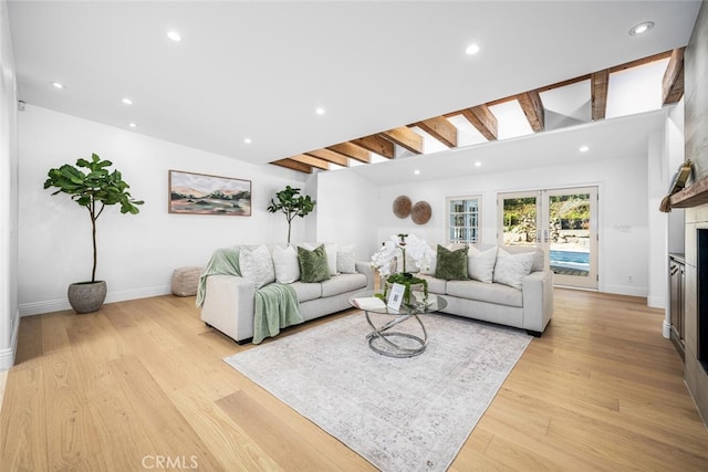 living room featuring light wood-style floors, recessed lighting, french doors, and a fireplace