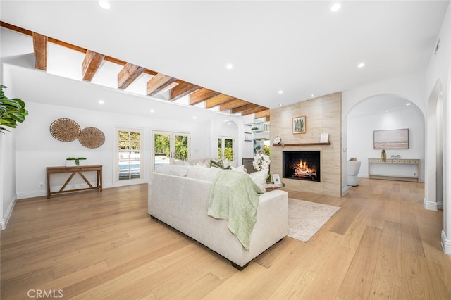 living area with light wood-style floors, baseboards, a large fireplace, and recessed lighting