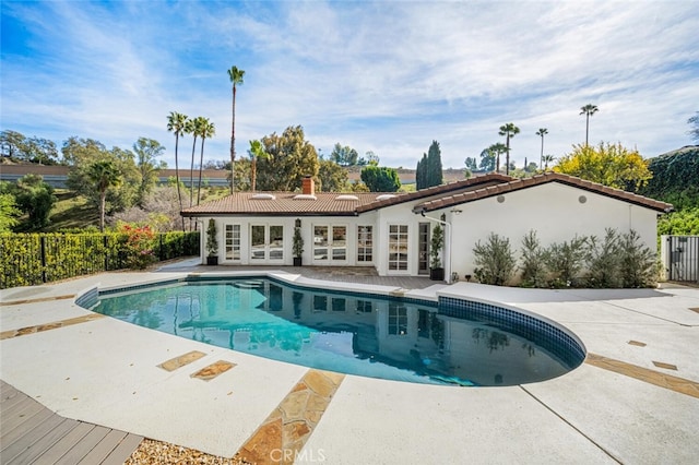 pool featuring a patio area, fence, and french doors