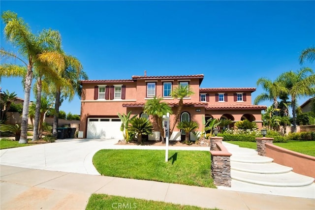 mediterranean / spanish home with a garage, concrete driveway, a tiled roof, a front lawn, and stucco siding