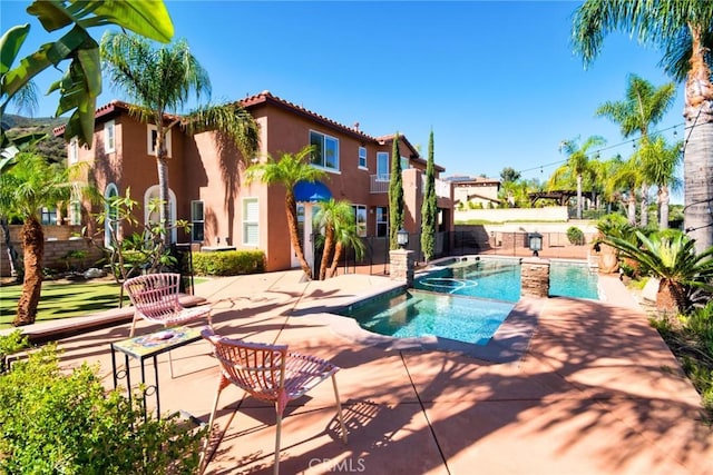 view of swimming pool with a pool with connected hot tub and a patio