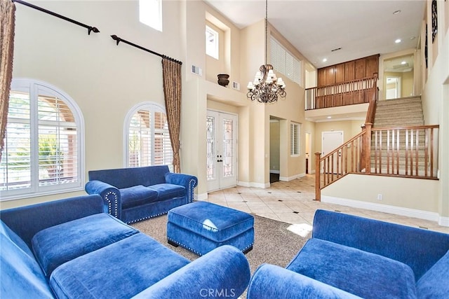 living area with light tile patterned flooring, a notable chandelier, visible vents, baseboards, and stairway