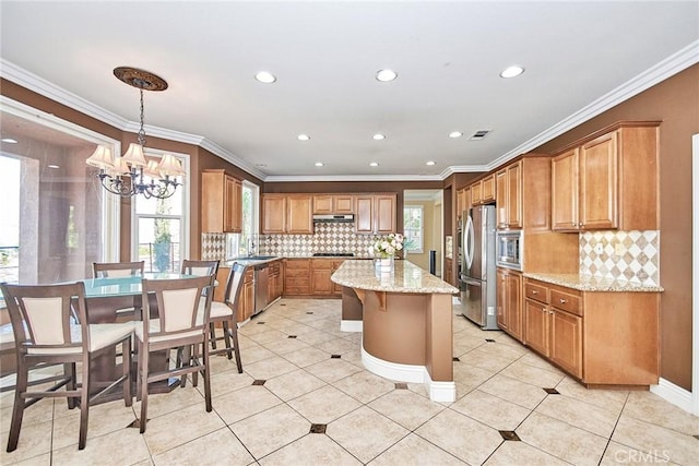 kitchen with light stone counters, brown cabinets, decorative light fixtures, appliances with stainless steel finishes, and a healthy amount of sunlight