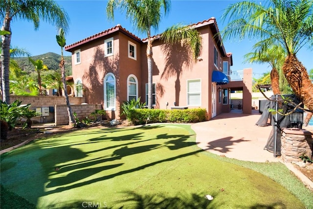 back of house with fence, a patio, a balcony, and stucco siding