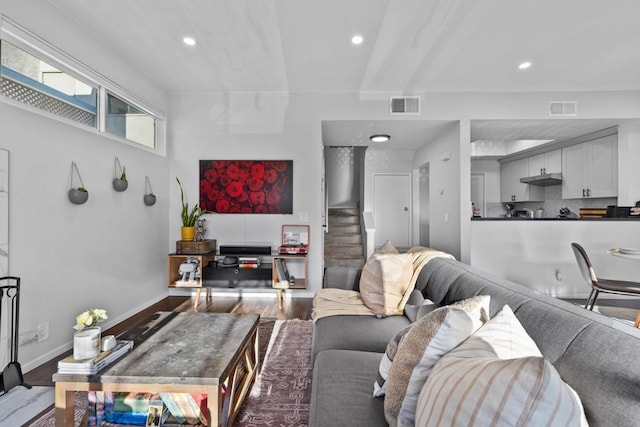 living area featuring stairway, wood finished floors, and visible vents