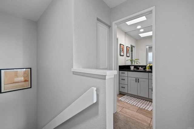 bathroom featuring a skylight, vanity, and recessed lighting