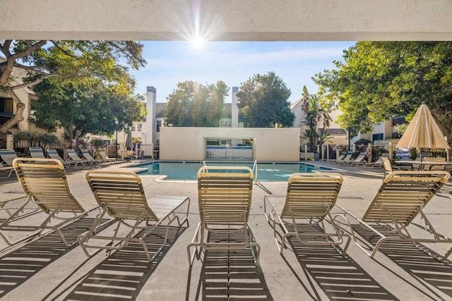 community pool with a patio and fence