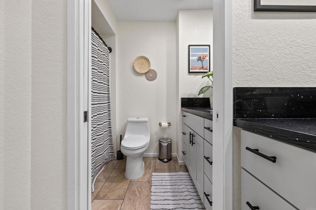 full bathroom with baseboards, vanity, and toilet