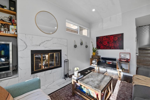 living area featuring recessed lighting, beverage cooler, a premium fireplace, and stairs