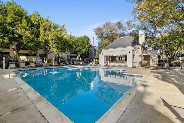 community pool featuring a patio and fence