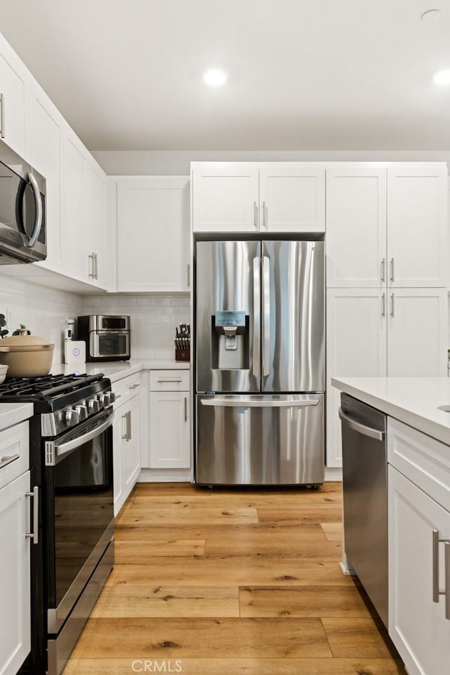 kitchen with light countertops, appliances with stainless steel finishes, and white cabinetry