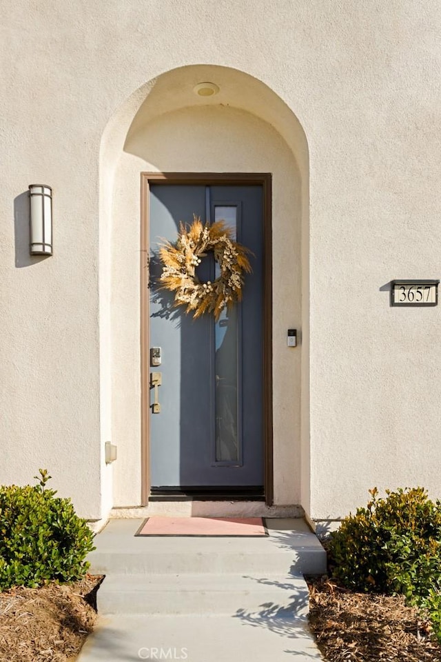 view of exterior entry featuring stucco siding