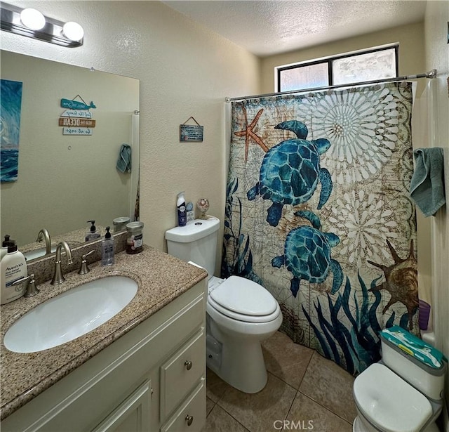 bathroom with toilet, tile patterned floors, a textured ceiling, vanity, and curtained shower