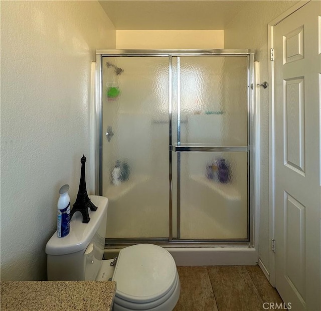 full bath with a stall shower and toilet