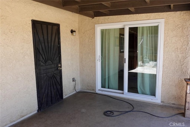 entrance to property featuring stucco siding