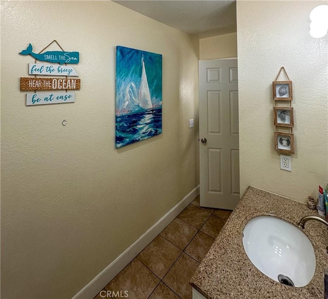 bathroom with tile patterned flooring, baseboards, and vanity
