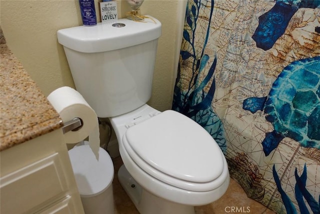 full bath with toilet and a textured wall
