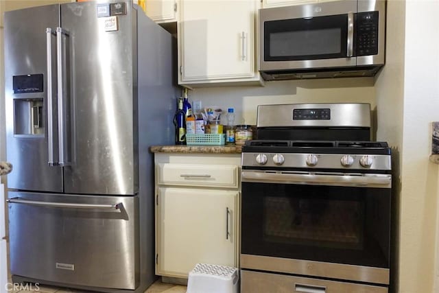 kitchen featuring stainless steel appliances, white cabinets, and light countertops