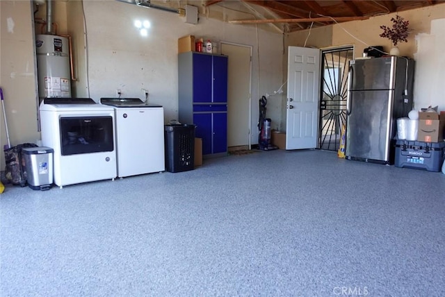 garage with washer and dryer, strapped water heater, and freestanding refrigerator