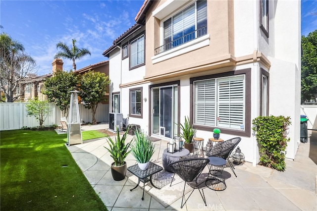 back of property with stucco siding, fence, and a patio