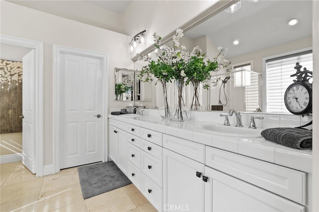 bathroom featuring double vanity, a sink, and recessed lighting