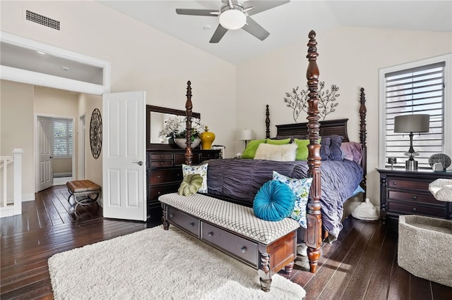 bedroom featuring dark wood-style floors, visible vents, vaulted ceiling, and a ceiling fan