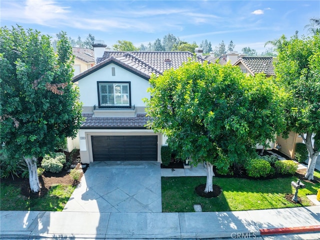 view of front of home with concrete driveway, an attached garage, a tile roof, and stucco siding