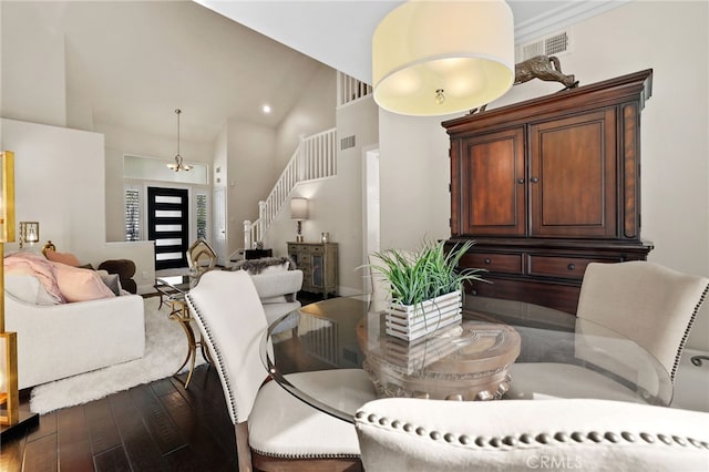 dining room with high vaulted ceiling, stairs, visible vents, and wood finished floors