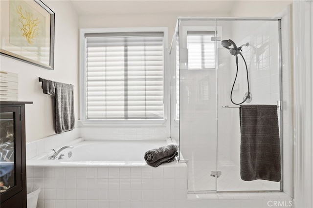 bathroom featuring a stall shower and a bath