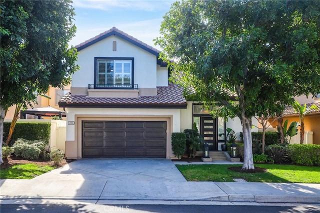 view of front of home featuring driveway, a tile roof, a garage, and stucco siding