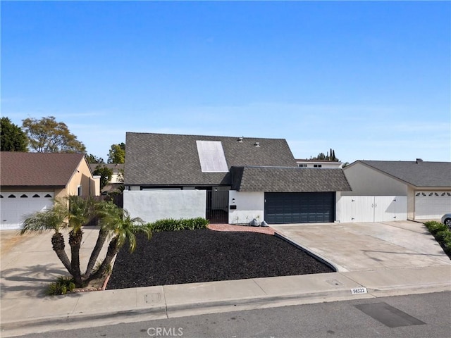 view of front facade featuring a garage, roof with shingles, driveway, and stucco siding