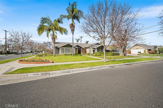 view of front facade featuring driveway, a residential view, and a front lawn