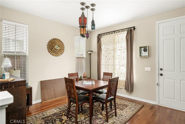 dining space with dark wood finished floors and baseboards