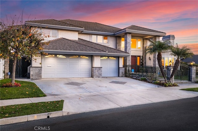 view of front of house with an attached garage, a fenced front yard, concrete driveway, and stucco siding