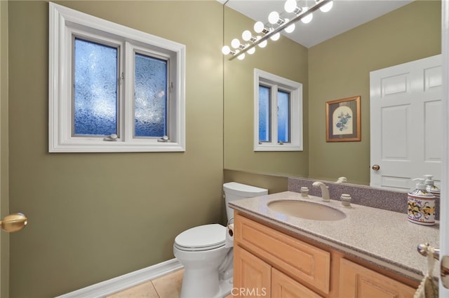 half bath featuring toilet, tile patterned floors, baseboards, and vanity