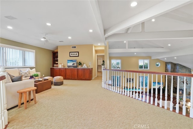 interior space with a wealth of natural light, light carpet, and lofted ceiling with beams