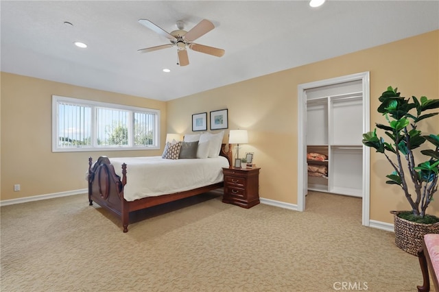 bedroom featuring light carpet, baseboards, ceiling fan, a walk in closet, and recessed lighting