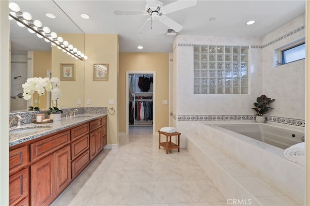 bathroom featuring recessed lighting, double vanity, a sink, and a bath