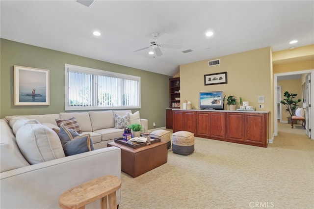 living room with a ceiling fan, recessed lighting, visible vents, and light colored carpet