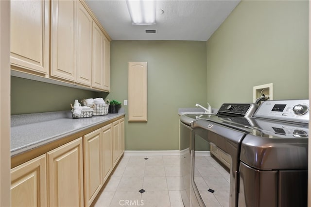 washroom with light tile patterned floors, cabinet space, visible vents, independent washer and dryer, and baseboards