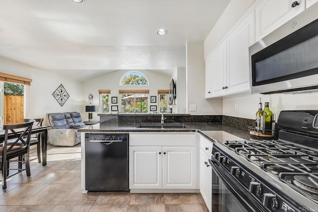 kitchen with open floor plan, black appliances, a sink, and white cabinetry