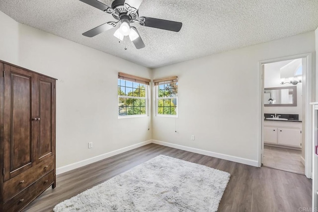 bedroom featuring a textured ceiling, dark wood-type flooring, and baseboards