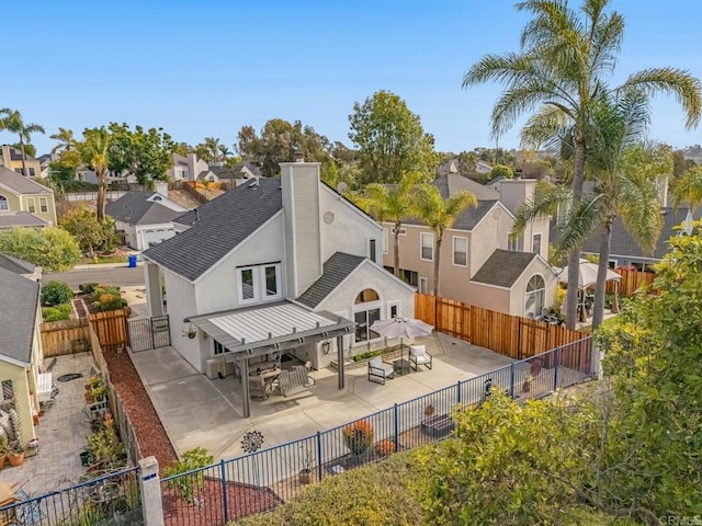 back of property featuring a fenced backyard, a residential view, and a patio