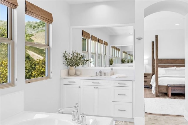 bathroom featuring a bathtub, connected bathroom, and vanity