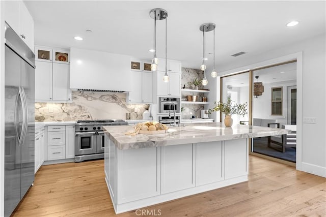 kitchen with visible vents, high end appliances, light wood-style flooring, custom range hood, and white cabinetry